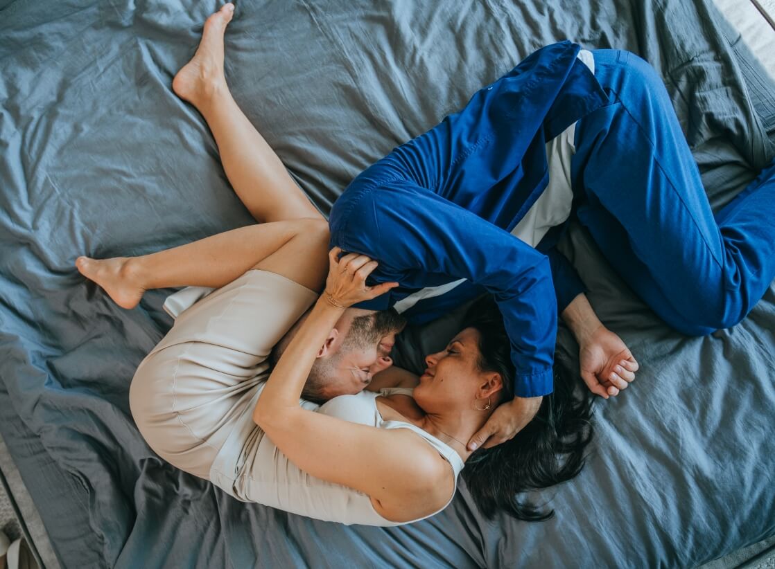 top-view-on-kissing-young-couple-laying-on-bed-hom-2023-11-27-05-05-46-utc (1)